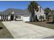 Charming home featuring a long driveway, two-car garage, palm trees and complementary dark-red window shutters at 59 Willowbend Dr., Murrells Inlet, SC 29576