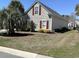 A lovely side yard, edged with well-maintained landscaping, featuring trimmed bushes and decorative brick at 59 Willowbend Dr., Murrells Inlet, SC 29576