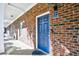 A welcoming blue door, number 214, set in a brick exterior with a well-lit, covered walkway at 6253 Catalina Dr. # 214, North Myrtle Beach, SC 29582