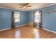 Bright bedroom with wood floors, ceiling fan, and natural light streaming through the windows at 7638 Highway 905, Longs, SC 29568