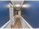 View of hallway with blue walls, white trim, and wood-look flooring at 7638 Highway 905, Longs, SC 29568