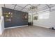 Spacious living room with dark brick wall, modern lighting, and hardwood floors at 7638 Highway 905, Longs, SC 29568