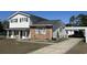 Exterior view of a house with white siding, brick accents, a carport, and a well-maintained lawn at 806 Duncan Ave., Myrtle Beach, SC 29572