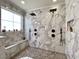 Luxurious walk-in shower with marble tile, dual shower heads, bench, and mosaic tile flooring at 817 Falkirk St., Myrtle Beach, SC 29579
