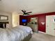 Red accent wall highlights a dresser with mirror, ceiling fan, and bed in the primary bedroom at 817 Falkirk St., Myrtle Beach, SC 29579