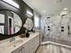 Modern bathroom features double vanity, walk-in shower with marble tile, and pebble flooring at 817 Falkirk St., Myrtle Beach, SC 29579