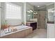 Luxurious bathroom featuring a soaking tub, glass shower, and elegant vanity with great lighting at 8504 Juxa Dr., Myrtle Beach, SC 29579