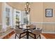 Cozy dining room featuring a round table, four chairs, chandelier, and natural light from large windows at 8504 Juxa Dr., Myrtle Beach, SC 29579