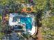 Aerial view of a community pool area with a jacuzzi, covered lounge, and surrounding trees at 86 Old Barge Dr., Pawleys Island, SC 29585