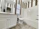 Neutral bathroom with white vanity, matching toilet, and striped wall design at 86 Old Barge Dr., Pawleys Island, SC 29585