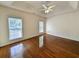 Bright bedroom with hardwood floors, ceiling fan, and two windows overlooking the neighborhood at 86 Old Barge Dr., Pawleys Island, SC 29585