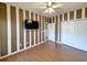 Bedroom features striped accent wall, ceiling fan, and hardwood floors at 86 Old Barge Dr., Pawleys Island, SC 29585