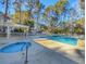 Community pool area showcasing a hot tub with sun loungers and lush trees at 86 Old Barge Dr., Pawleys Island, SC 29585