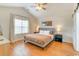 Cozy main bedroom with a vaulted ceiling, hardwood floors, and natural light from a large window at 9648 Bradford Ln., Murrells Inlet, SC 29576