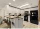 Bright kitchen with white cabinetry, granite countertops, and stainless steel sink and black appliances at 9994 Beach Club Dr. # 1904, Myrtle Beach, SC 29572