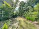 Lush backyard with grass, trees, and a stone garden, offering a serene and private outdoor space at 1219 Inlet View Dr., North Myrtle Beach, SC 29582