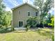 The back of a tan home shows the slider to the patio, the manicured lawn, and a rock garden at 1219 Inlet View Dr., North Myrtle Beach, SC 29582