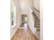 Bright hallway featuring hardwood floors, high ceilings, and a staircase with carpeted steps at 1219 Inlet View Dr., North Myrtle Beach, SC 29582