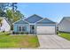 Desirable single-story home boasts a manicured lawn, two-car garage, tasteful landscaping, and classic blue siding at 361 Rycola Circle, Myrtle Beach, SC 29575