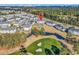 Expansive aerial view of a condo community featuring a pool, golf course, and scenic landscape with ocean views in the distance at 4827 Orchid Way # 301, Myrtle Beach, SC 29577