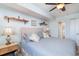 Bright bedroom with light blue walls, ceiling fan, and queen bed with nautical decor on shelves at 501 S Ocean Blvd. # 1002, North Myrtle Beach, SC 29582
