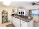 Kitchen area with stainless sink, white cabinetry, and view into the living area and ocean at 501 S Ocean Blvd. # 1002, North Myrtle Beach, SC 29582