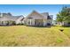 Large backyard with green grass, patio with seating, and view of rear exterior at 542 Sand Ridge Rd., Conway, SC 29526