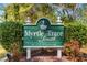 Community sign for Myrtle Trace South, a 55+ community, with lush greenery at 542 Sand Ridge Rd., Conway, SC 29526