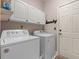 Bright laundry room with washer, dryer, white cabinets and door to outside at 542 Sand Ridge Rd., Conway, SC 29526
