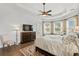 Bright main bedroom featuring a tray ceiling, large windows, and a seating area, promoting relaxation at 7268 Seville Dr., Myrtle Beach, SC 29572