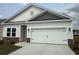 Charming single-Gathering home featuring a white garage door and stone accents on the facade at 1025 Jase Dr., Longs, SC 29568
