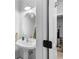 Clean bathroom featuring a pedestal sink and round mirror at 111 Maddux Ln. # B, Myrtle Beach, SC 29588