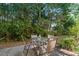 Outdoor patio with glass table and chairs, surrounded by lush greenery at 111 Maddux Ln. # B, Myrtle Beach, SC 29588