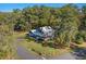 Expansive aerial view of a blue home with a large yard, surrounded by lush greenery and mature trees at 160 Shipmaster Ave., Pawleys Island, SC 29585