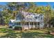 Charming two-story blue home featuring a lovely front porch and well-manicured landscaping at 160 Shipmaster Ave., Pawleys Island, SC 29585