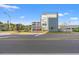 Three-story condo building showcasing exterior features like covered parking and a rooftop deck on a partly sunny day at 2010 S Ocean Blvd., Myrtle Beach, SC 29577