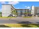 Condominium building with palm trees in front of it and vehicle parking with horizontal blue painted windows at 2010 S Ocean Blvd., Myrtle Beach, SC 29577