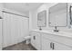 Bright bathroom featuring a double sink vanity with black fixtures, mirrors, and a shower and tub combination at 206 Math Place, Longs, SC 29568