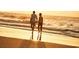 A couple enjoys a romantic stroll along a pristine beach at sunset, the golden light reflecting off the water and sand at 247 Warner Crossing Way, Loris, SC 29569