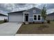 Charming single-story home with light blue siding, attached garage, and well-maintained landscaping at 247 Warner Crossing Way, Loris, SC 29569