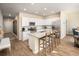 Spacious kitchen with white cabinets, stainless steel appliances, an island with seating, and hardwood floors at 247 Warner Crossing Way, Loris, SC 29569