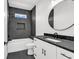 Charming bathroom with a modern vanity, dark countertop, and a large round mirror at 318 Vista Dr., Murrells Inlet, SC 29576