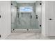 Beautiful bathroom featuring glass shower with rainfall shower head and marble tile at 318 Vista Dr., Murrells Inlet, SC 29576