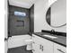 Charming bathroom with a modern vanity, dark countertop, and a large round mirror at 318 Vista Dr., Murrells Inlet, SC 29576