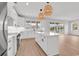 Modern kitchen features white cabinets, a large island, stainless steel appliances, and stylish pendant lighting at 318 Vista Dr., Murrells Inlet, SC 29576