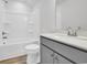 Bright bathroom featuring a tub, a toilet and a sink with gray cabinets at 415 Joseph St, Longs, SC 29568