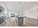 Open kitchen with granite countertops, gray cabinets, stainless appliances, and hardwood floors at 415 Joseph St, Longs, SC 29568