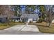 Single-story home with a well-kept lawn, concrete driveway, and mature trees enhancing curb appeal at 6454 Sweet Gum Trail, Myrtle Beach, SC 29588