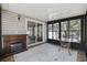 Sunroom with windows, fireplace, tile floors, and a glass-topped table at 6454 Sweet Gum Trail, Myrtle Beach, SC 29588