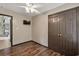 Bedroom featuring wood floors, ceiling fan, view into living room, closet, and television at 1047 Holt Rd., Conway, SC 29526